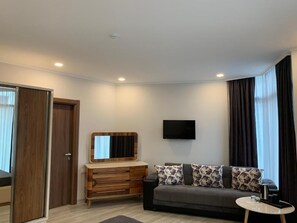 Habitación triple Deluxe | Zona de estar