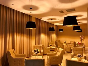 A room with multiple seating areas, including sofas and armchairs, arranged around a central table. - Tsereteli Palace (Batumi)