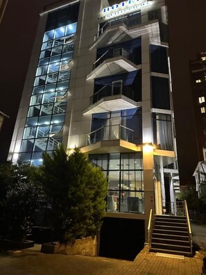 A multi-story hotel with a glass facade, outdoor stairs, and a well-lit entrance. - Tsereteli Palace (Batumi)