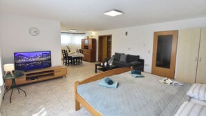 A hotel room with a bed, a TV, a dining area, and a wardrobe. - Relaxing villa with smart layout (Križine)