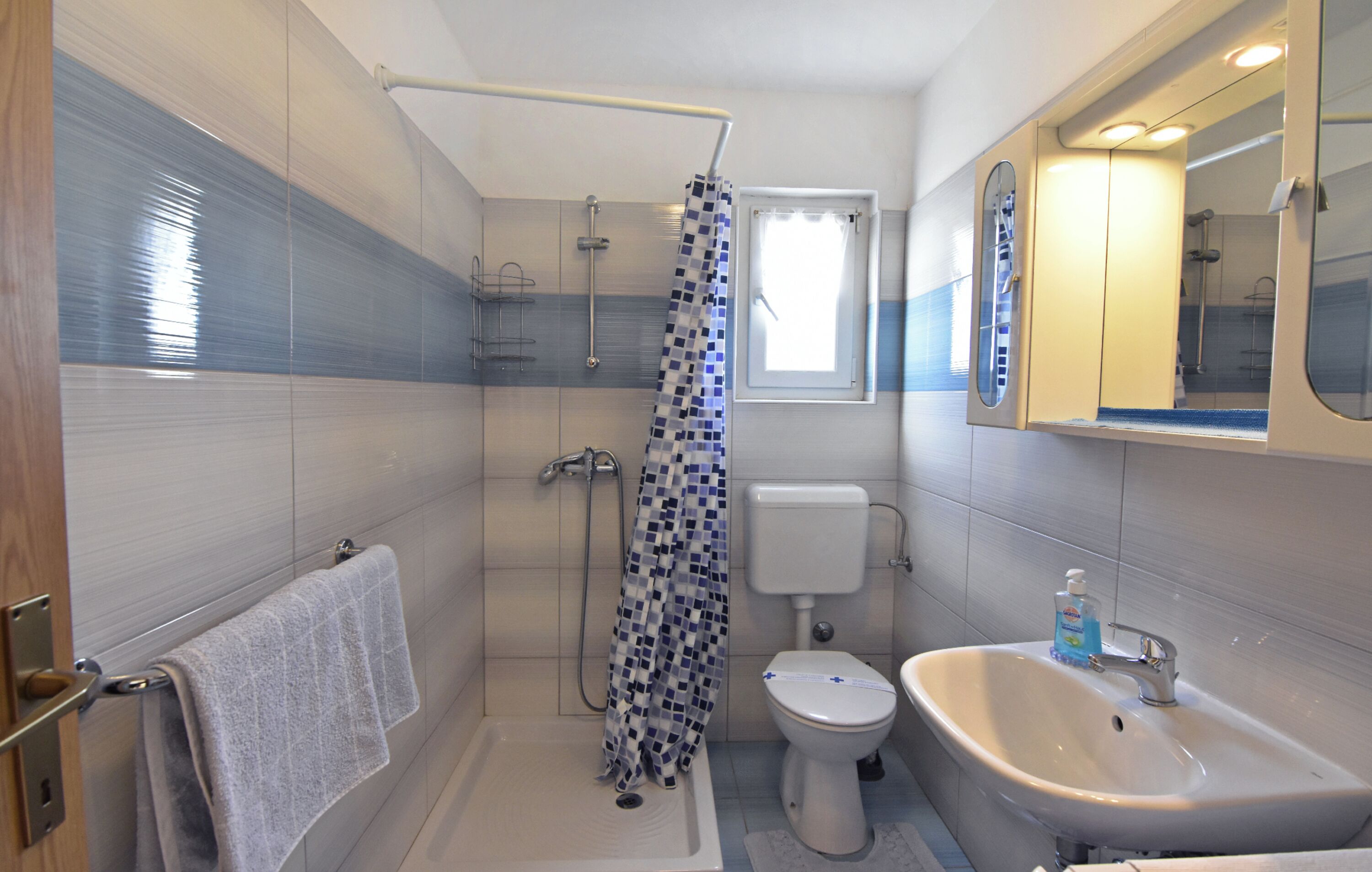 Ein Badezimmer mit Dusche, Toilette, Waschbecken und Handtuchhalter.