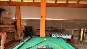 Ein Billardtisch mit grüner Spielvliesdecke, umgeben von sechseckigen Fliesen.