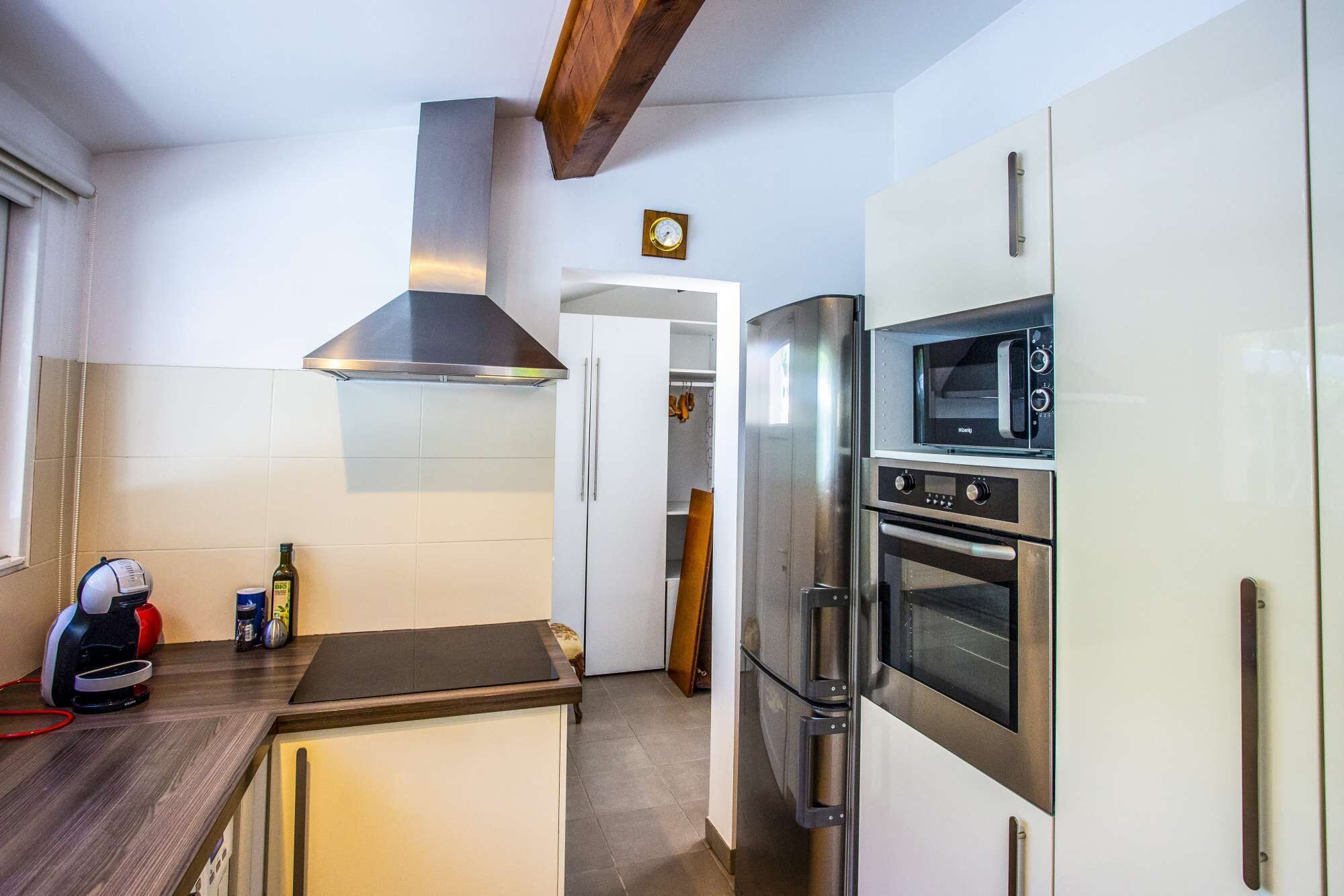 A modern kitchen with stainless steel appliances, a built-in oven, and a microwave.
