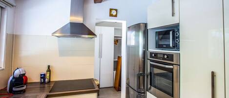 A modern kitchen with stainless steel appliances, a built-in oven, and a microwave.