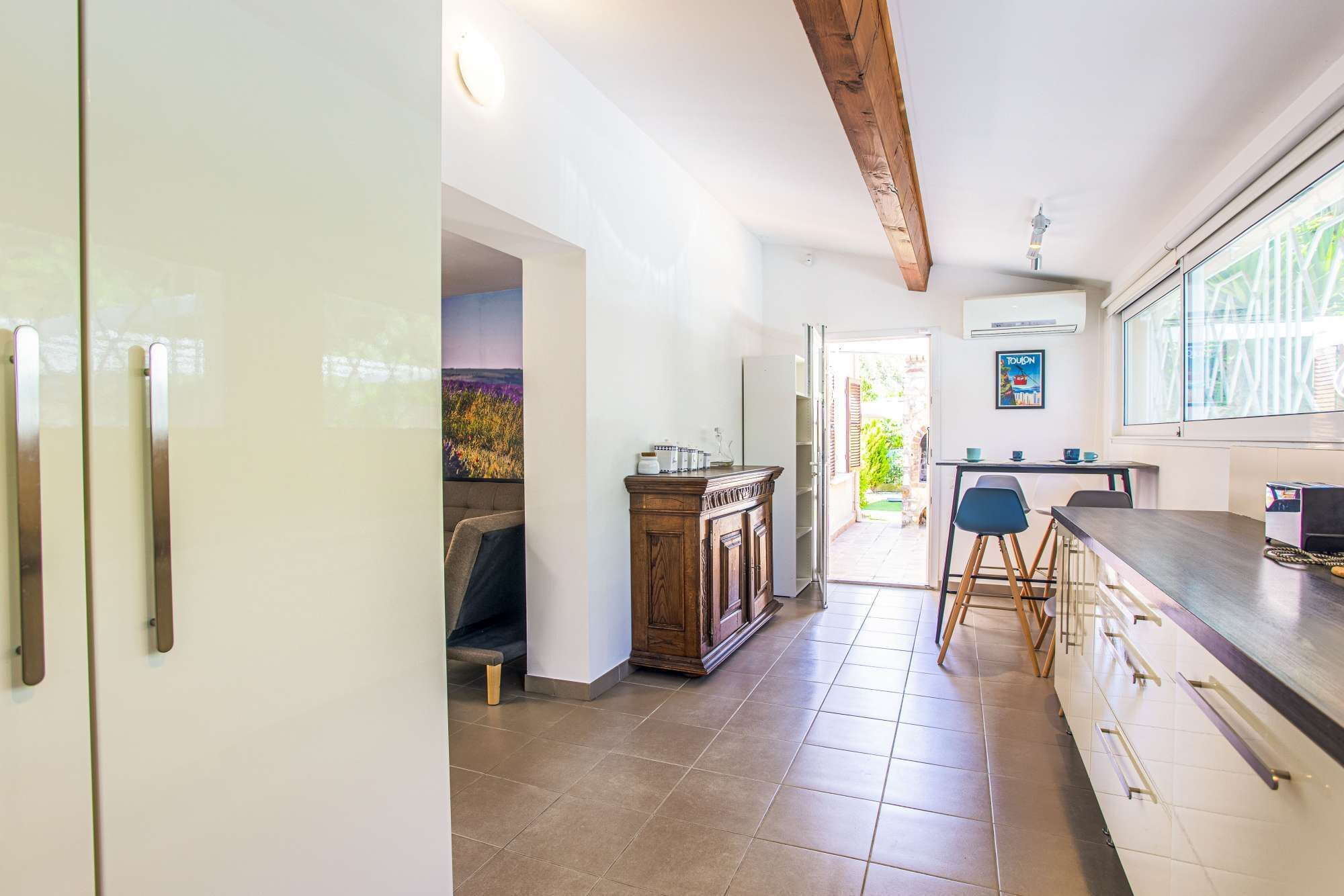 Een keuken met een houten plafond, een eethoek met stoelen en uitzicht op de omgeving.