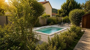 Piscina rectangular rodeada de grava, con zona de patio y mobiliario exterior.