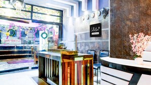 A reception area with a modern counter, a clock, and a sign that reads 'Collection.' - Premium Circus Avenue Rockstar (Kolkata)