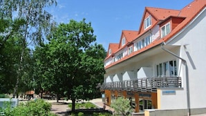 A building with a red-tiled roof, multiple windows, and a covered outdoor area with a railing. - 3 Person Holiday Park Home in Sassenburg (Sassenburg)