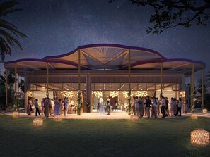 A covered outdoor event space with a central open area, surrounded by seating arrangements and decorative lighting. - Raffles The Red Sea (Umluj)