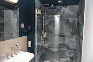 A modern bathroom with a glass-enclosed shower, a sink with a mirror, and a toilet with a wall-mounted bidet. - The Originals Boutique Osmo Hôtel (Chantepie)