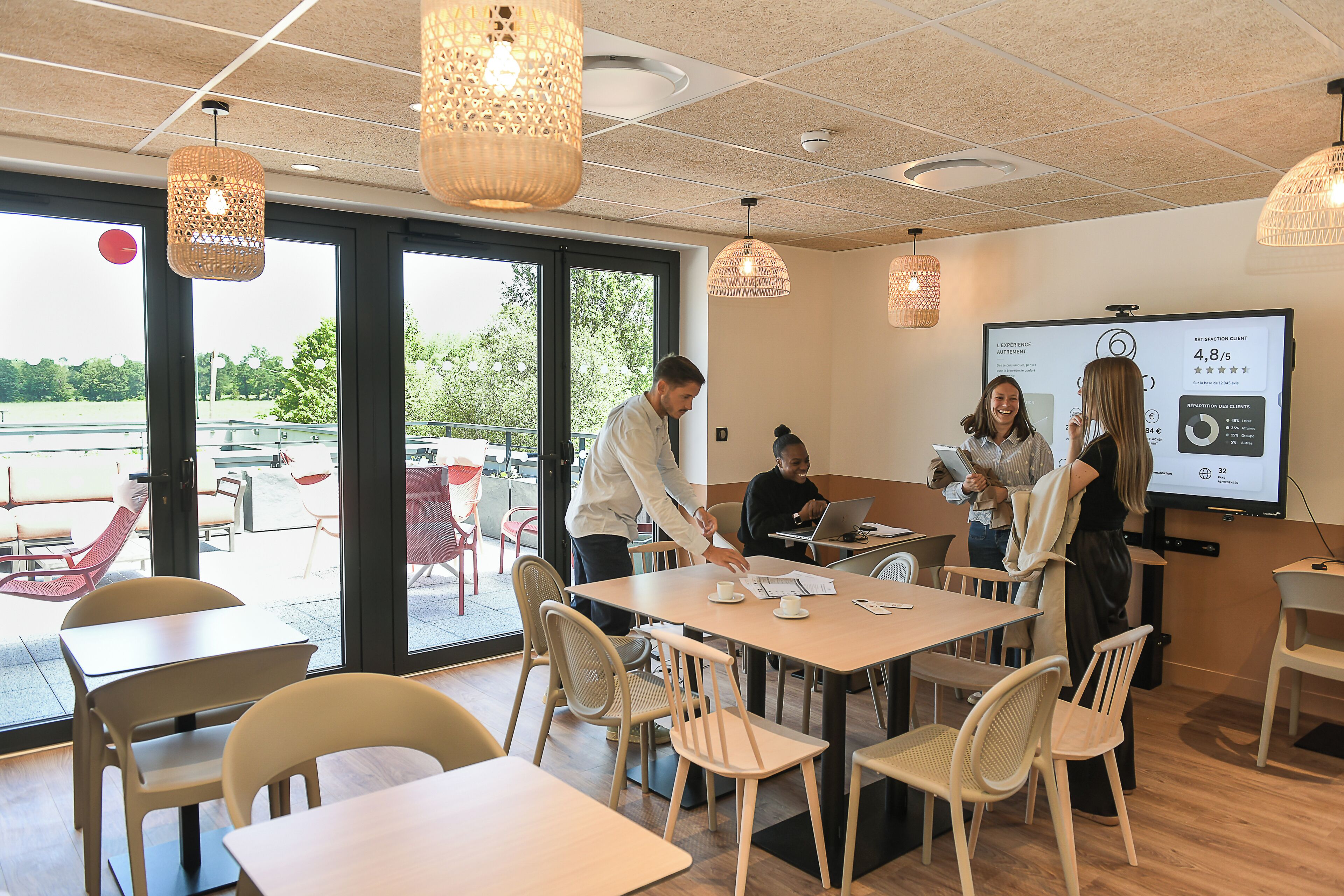 A meeting room with tables, chairs, and a presentation screen displaying a satisfaction score.