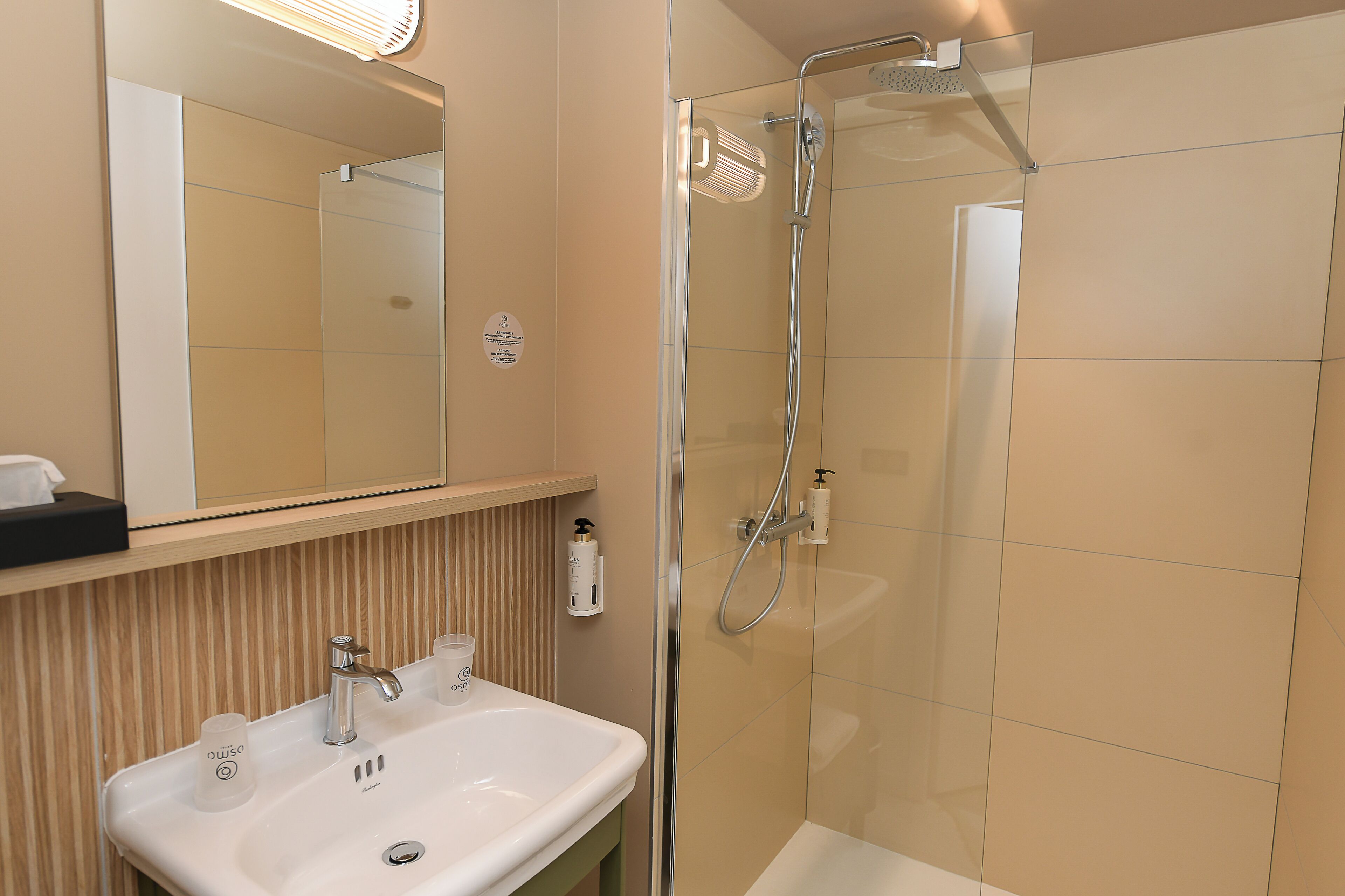A bathroom with a sink, mirror, and shower.
