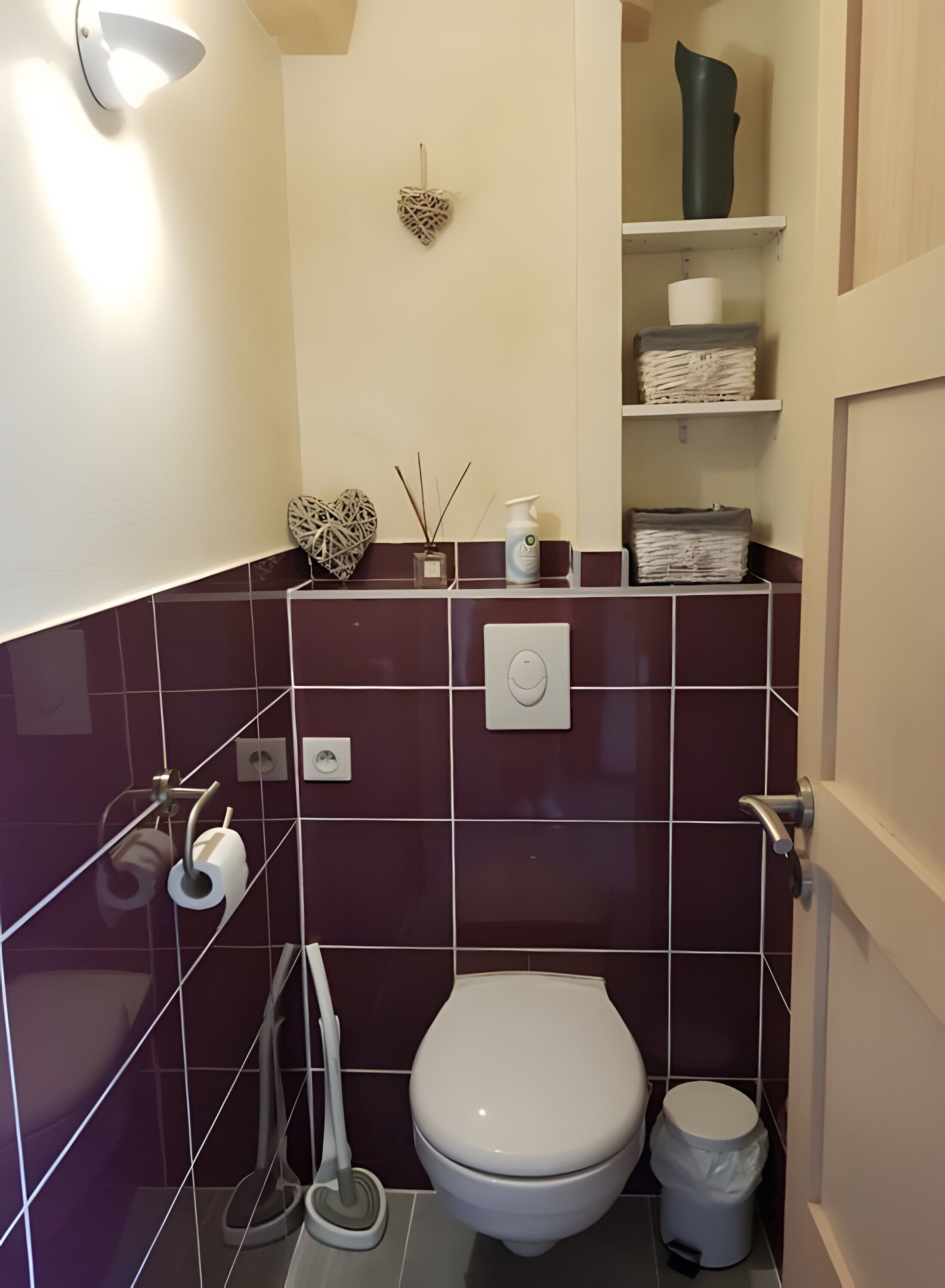 Une salle de bain équipée de toilettes, d’un bidet et d’une étagère où sont rangés les articles de toilette.