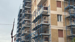 Een meerlaags gebouw met steigers, wat wijst op bouw- of renovatiewerkzaamheden.