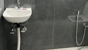 A bathroom with a white sink, a mirror, and a shower. - Hotel Prime Stay (New Delhi)