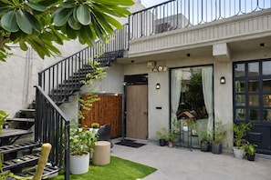 A modern building with a staircase, outdoor seating, and potted plants. - The Luxury Penthouse IGI Airport Delhi (New Delhi)