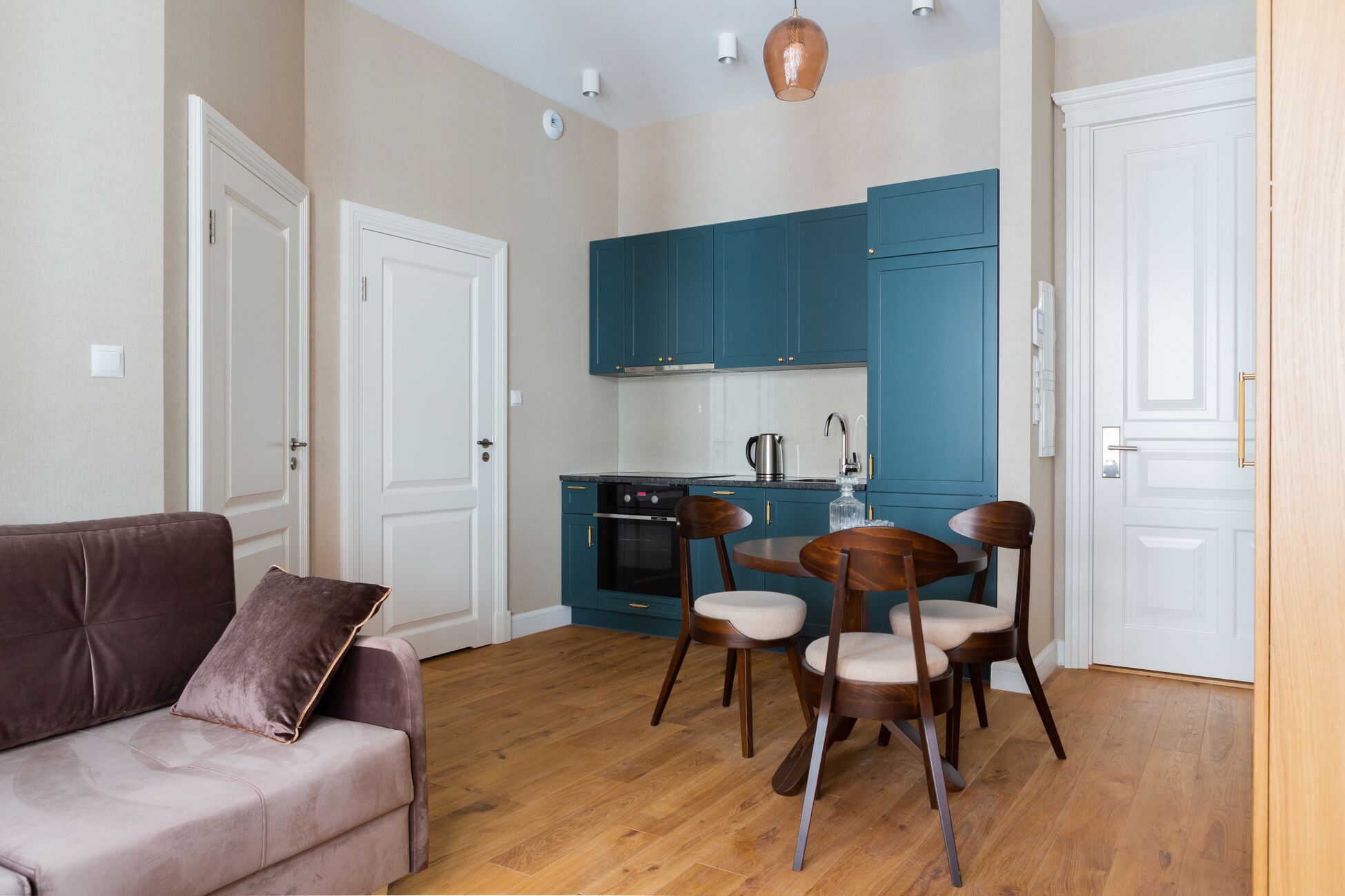 A compact living space with a kitchenette, a sofa, and a dining area.