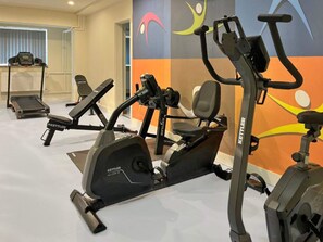 A gym with stationary bikes, a treadmill, and a wall with colorful artwork. - 2 Person Holiday Park Home in Erlbach (Markneukirchen)