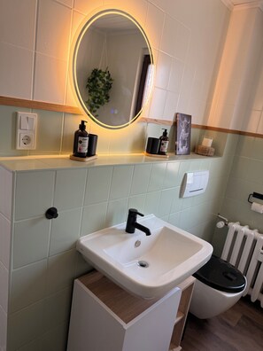 Een haardroger, handdoeken, zeep, toiletpapier