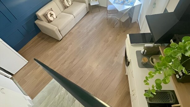 Ein modernes Wohnzimmer mit einer Couch, einem Esstisch und einer Treppe.
