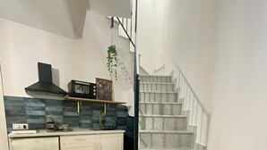 Eine moderne Küche mit weißen Schränken, einer schwarzen Dunstabzugshaube und einer blau gefliesten Spritzschutzwand.