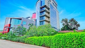 A modern building with a curved facade, multiple floors, and a mix of glass and concrete materials.
