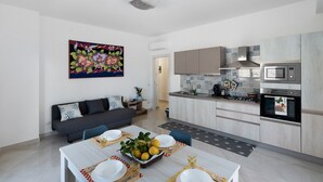 Une cuisine moderne équipée d’un four à micro-ondes, d’un four traditionnel et d’un coin repas avec une table dressée pour deux personnes.