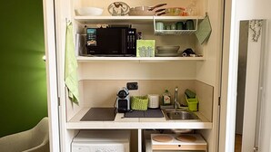 Une cuisine compacte équipée d’un four à micro-ondes, d’un évier et d’un lave-linge.