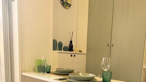 Un coin repas avec une table blanche, une chaise blanche et une cuisine en arrière-plan.