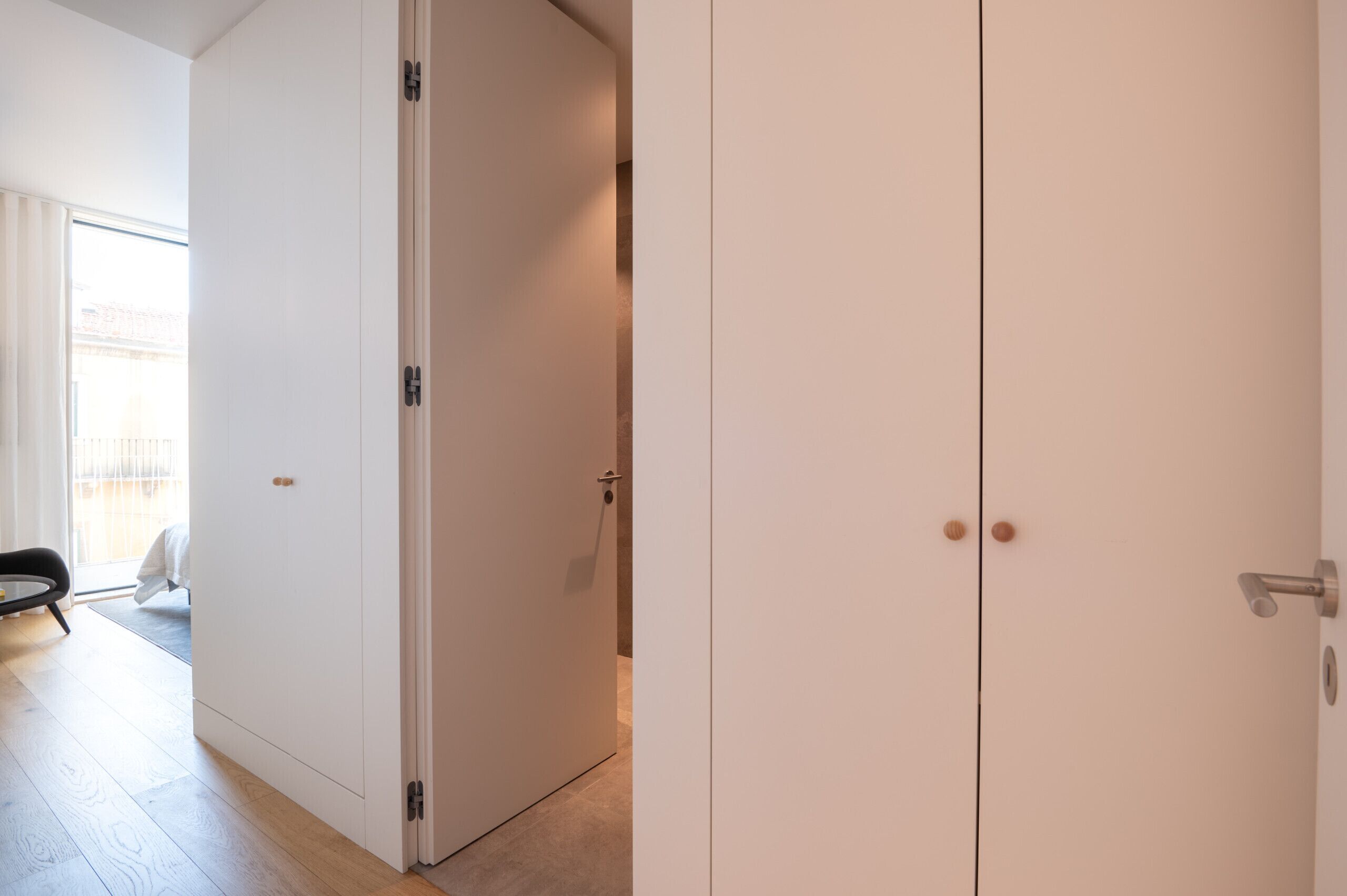 Una habitación con puerta corredera, manija visible y suelo de tonos claros.