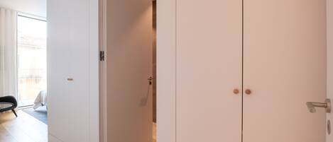 Una habitación con puerta corredera, manija visible y suelo de tonos claros.