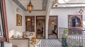 A traditional Moroccan interior with tiled flooring, ornate wooden doors, and hanging lanterns. - Riad Nostalgia & Spa (Marrakech)