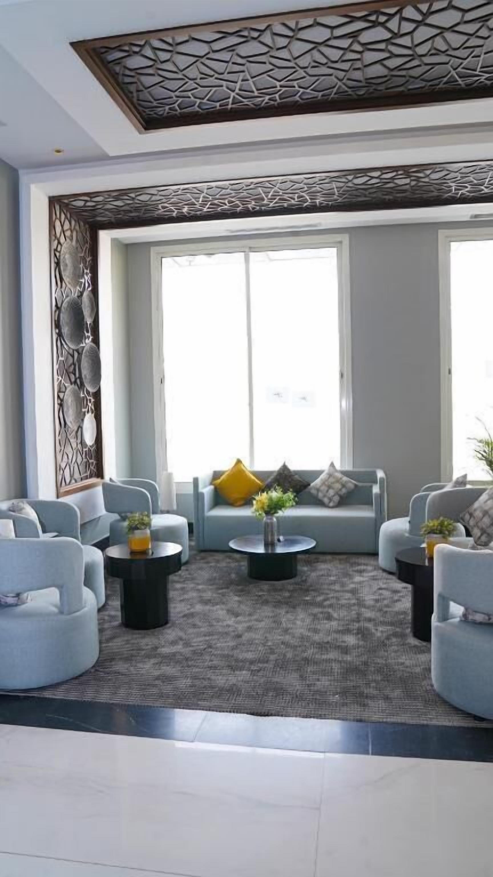A modern living room with a sofa set, coffee table, and decorative wall paneling.