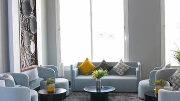 A modern living room with a sofa set, coffee table, and decorative wall paneling.