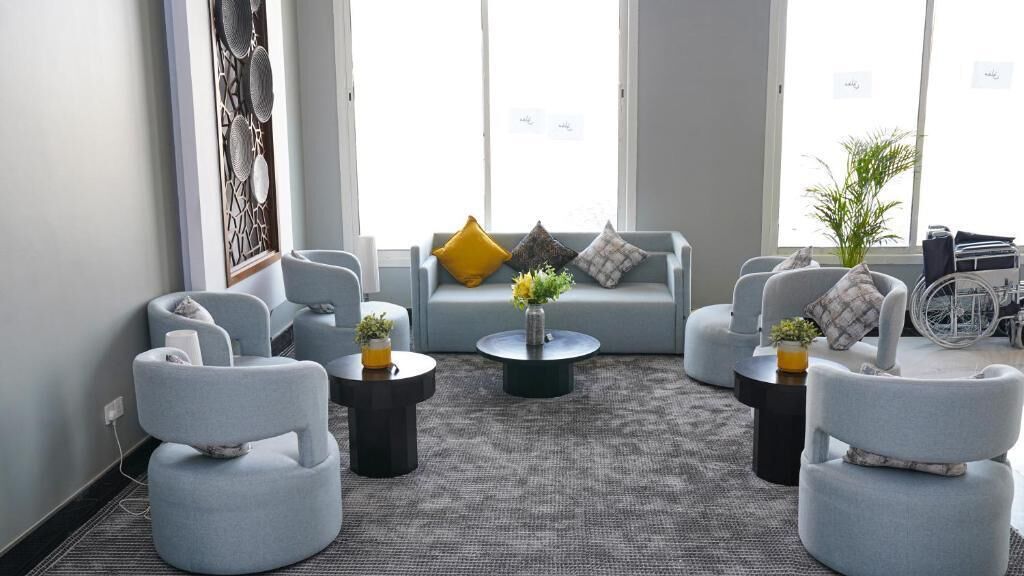 Een moderne woonkamer met een bank, fauteuils en een salontafel.
