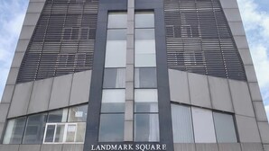 Un grand immeuble sur lequel on peut voir, à sa base, une enseigne bien visible indiquant « LANDMARK SQUARE ».