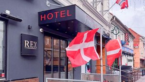 A hotel facade with a prominent 'HOTEL' sign, a 'REX' sign, and two Danish flags. - 1 Person Holiday Park Home in Aalborg (Aalborg)