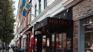 A hotel named 'HOTELY JOMFRUANE' with a black facade, large windows, and a visible flag. - 1 Person Holiday Park Home in Aalborg (Aalborg)
