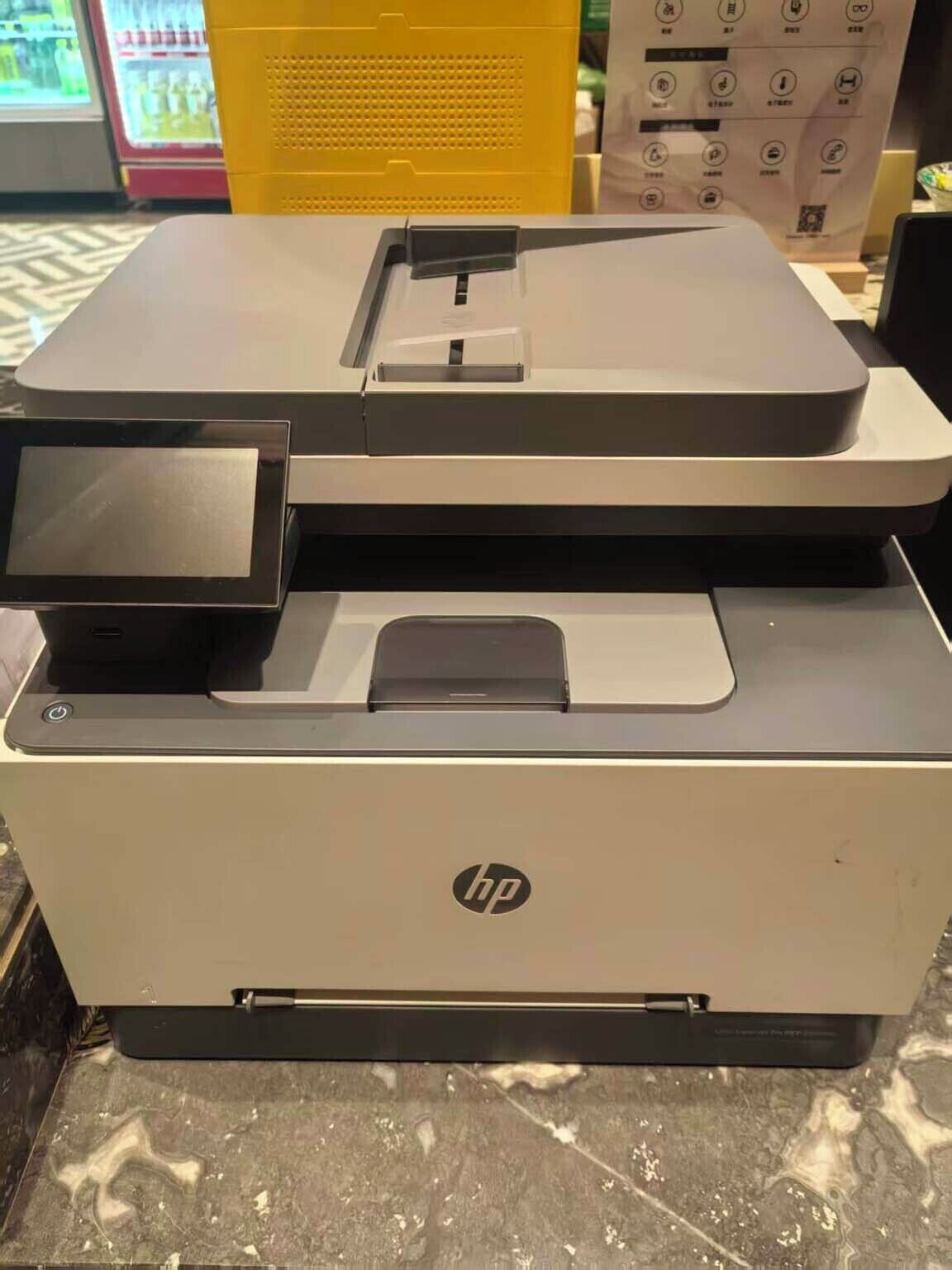 A large, modern HP printer with a control panel and a paper tray.