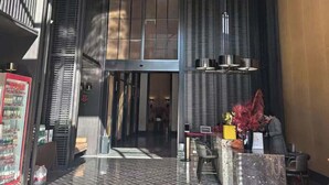 Un hall d’entrée moderne avec un sol à motifs, un comptoir d’accueil et un distributeur automatique.