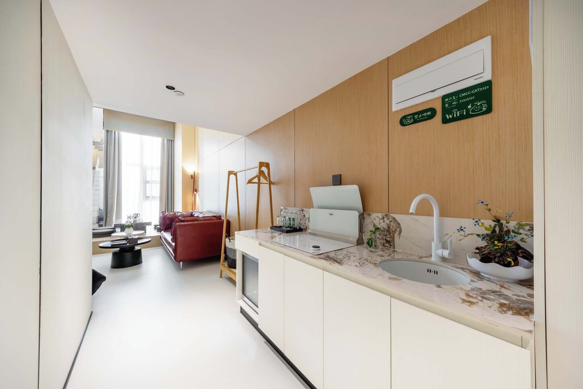 A modern kitchen with a sink, countertop, and wooden paneling.