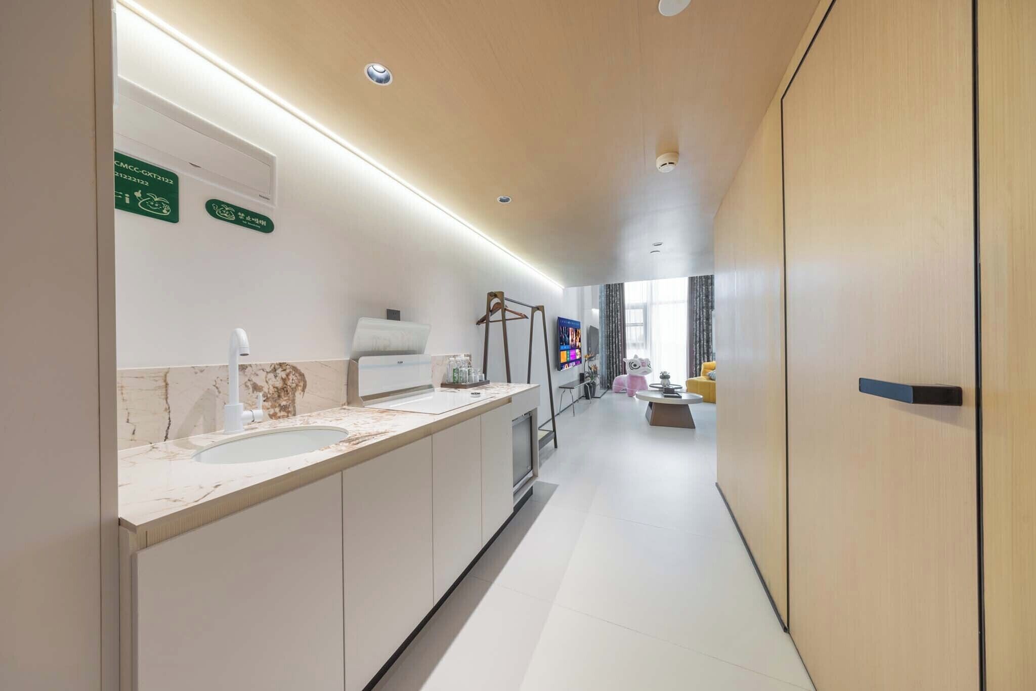 A modern bathroom with a marble countertop, a sink, and a mirror. There are signs on the wall indicating facilities.