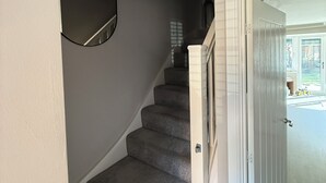 A staircase with carpeted steps, a white door, and a view into a room with a window and a toy car. - Beautiful family home in stunning Yorkshire village between York and Leeds (Tadcaster)