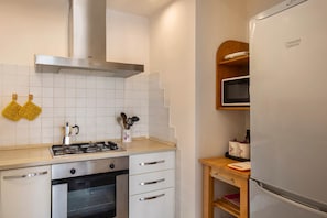 Eine Küche mit Herd, Backofen, Mikrowelle und Kühlschrank.