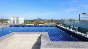 Ein Pool auf dem Dach mit freiem Blick auf Gebäude und ein Berg in der Ferne.