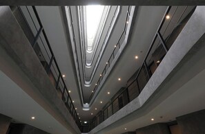 Ein mehrgeschossiges Interieur mit einem zentralen Atrium, Balkonen und einem modernen Design.