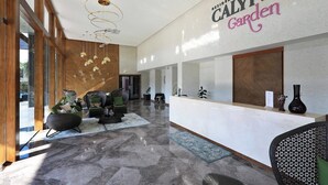 A modern reception area with a reception desk, seating, and a large window. - 2 bdr Apartment with bath NaiHarn Beach (Rawai)
