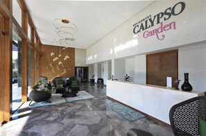 A modern reception area with a reception desk, seating, and a large window. - 2 bdr Apartment with bath NaiHarn Beach (Rawai)