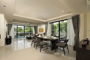 A spacious living area with a dining table, chairs, and a sofa. - Laguna Park | Bangtao Beach | 5-bedroom Pool Villa (Bangtao)
