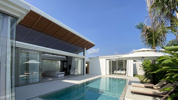 Uma casa moderna com piscina, portas de vidro e área de varanda coberta.